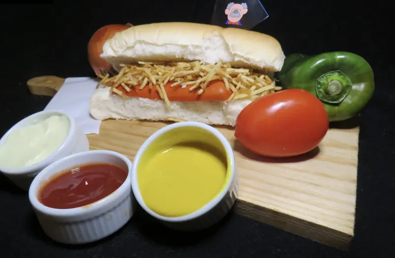 Hot dog Kids do Seu Zé com vina e batata palha, servido com maionese, catchup e mostarda